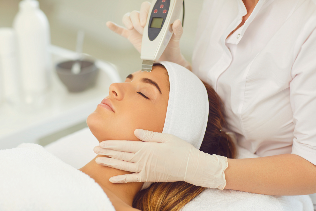 Woman Receiving Ultrasound Apparatus Facial Cleaning in Beauty Salon